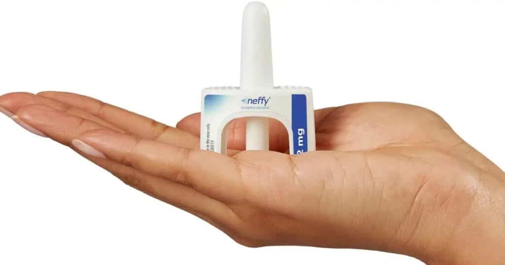 a hand holding a neffy adrenaline nasal spray device