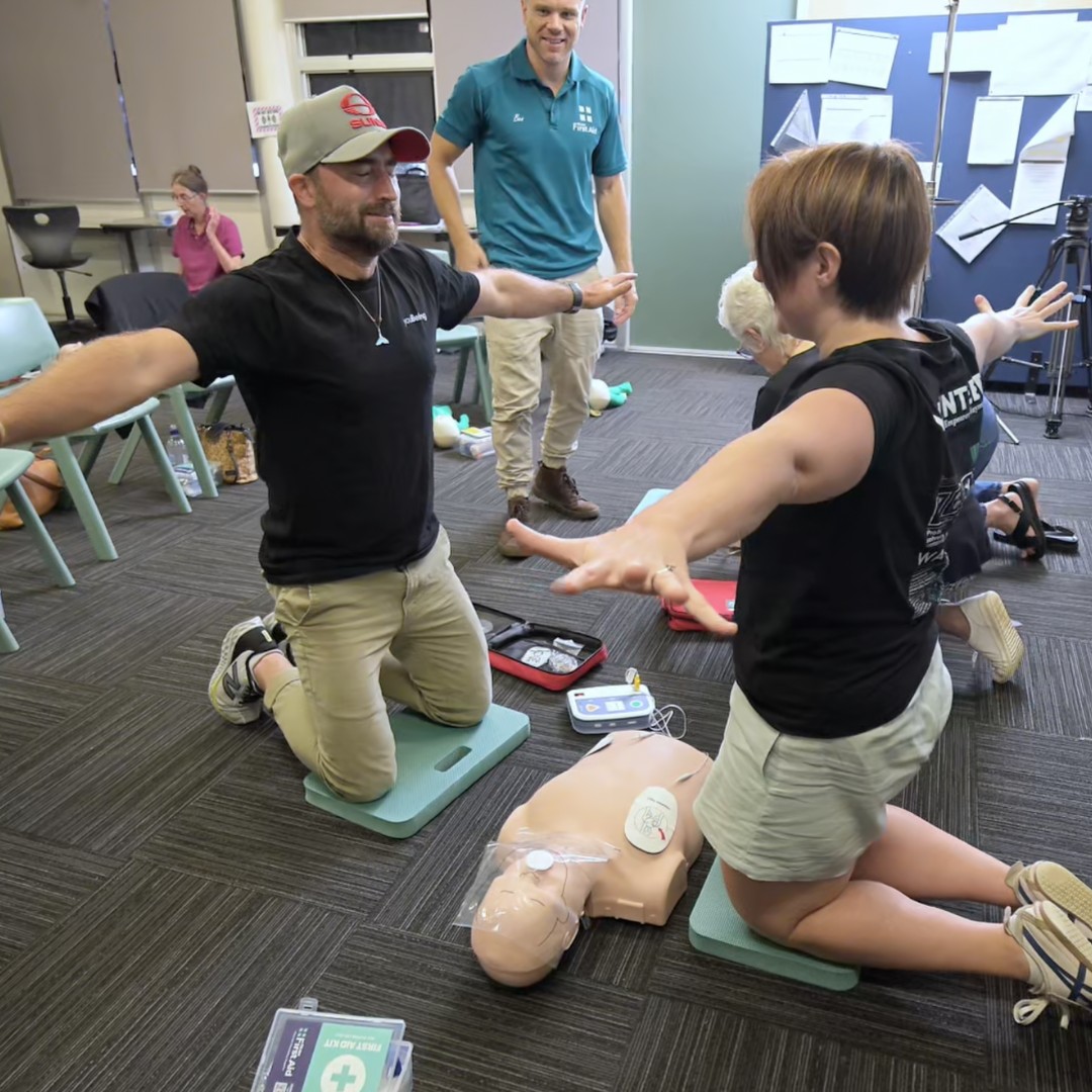Hands-on CPR and defibrillator practice at a workplace session